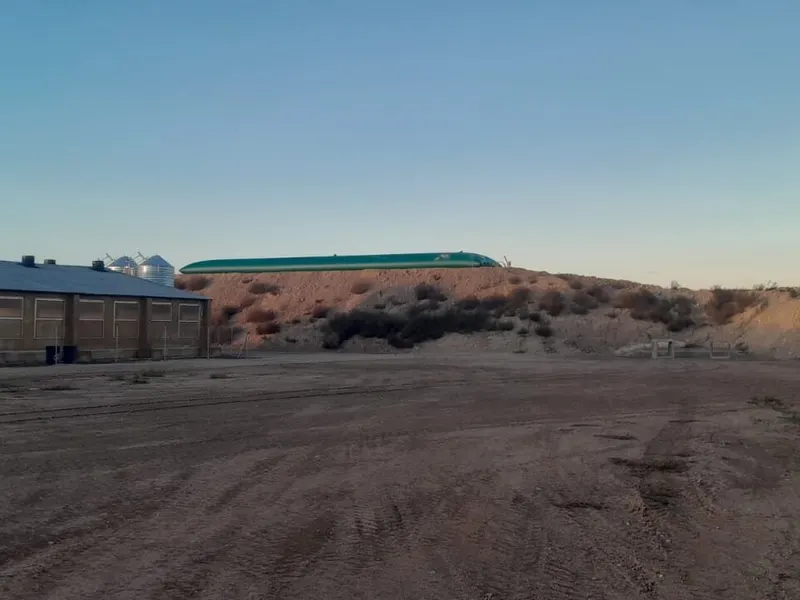 Cisterna flexible instalada sobre un talud junto a una explotación ganadera