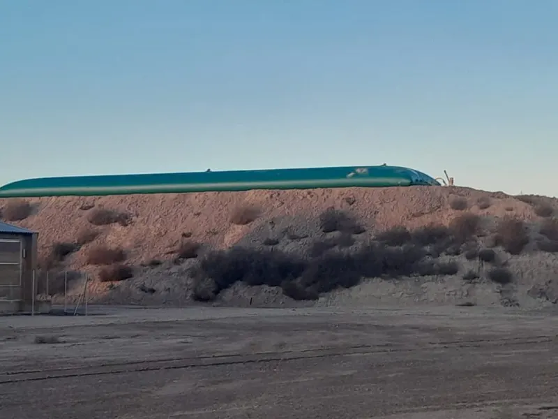 Cisterna flexible de gran capacidad instalada junto a una nave ganadera con silos