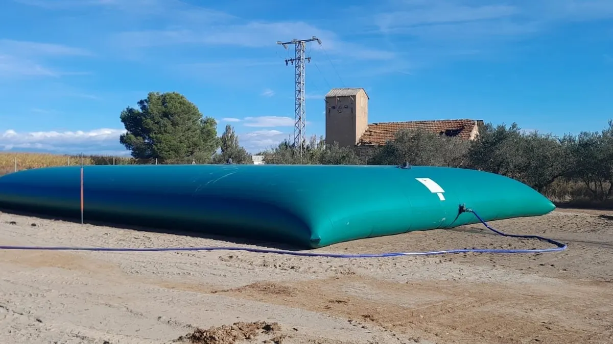 Depósito flexible para agua de riego instalado en una finca agrícola con olivos