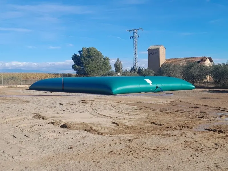 Depósito flexible para agua de riego instalado junto a un campo de maíz