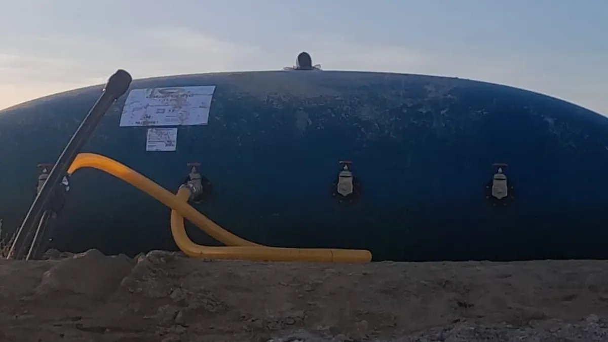 Depósito flexible de gran capacidad con cuatro válvulas de salida y placa de identificación, instalado sobre superficie preparada